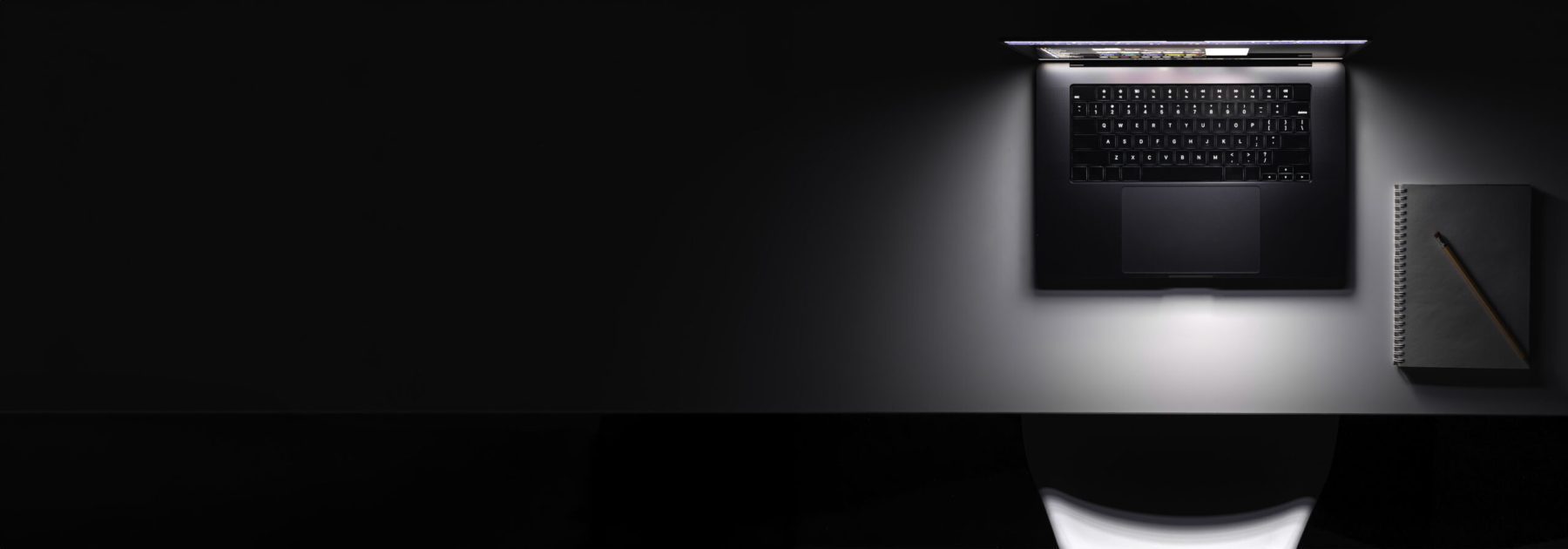 laptop with glowing screen table dark top view copy space scaled