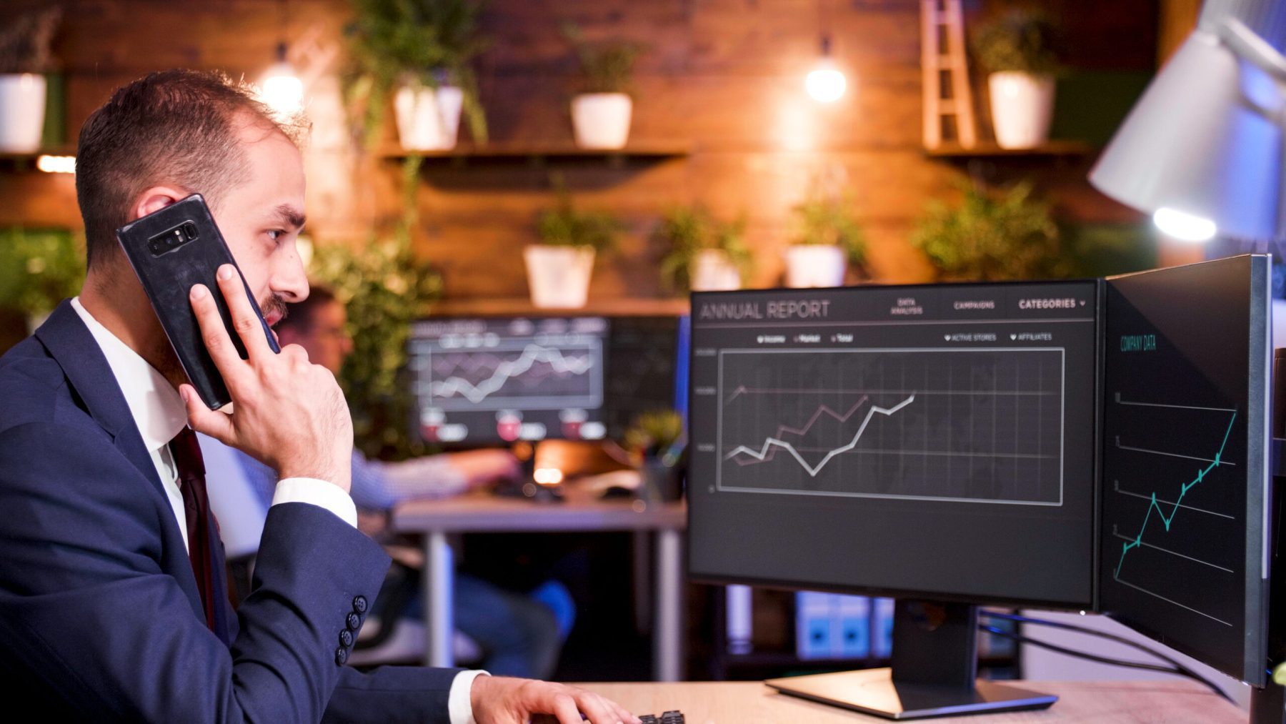 businessman talking phone while working computer modern office scaled